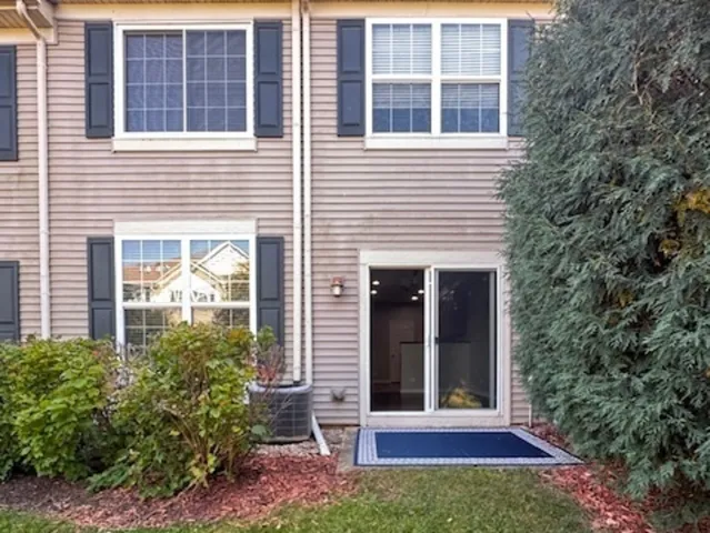 a view of a brick house with a large window and potted plants