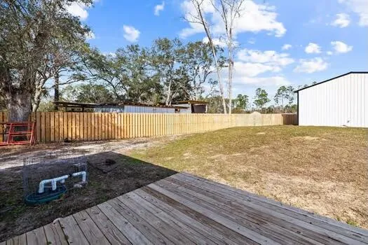 a view of an ocean & house with yard and sitting area