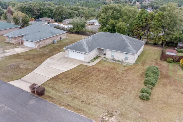 an aerial view of a house with a yard and parking space