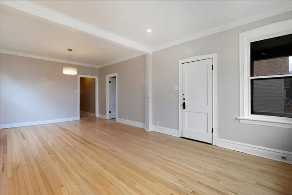 a view of an empty room with wooden floor and closet