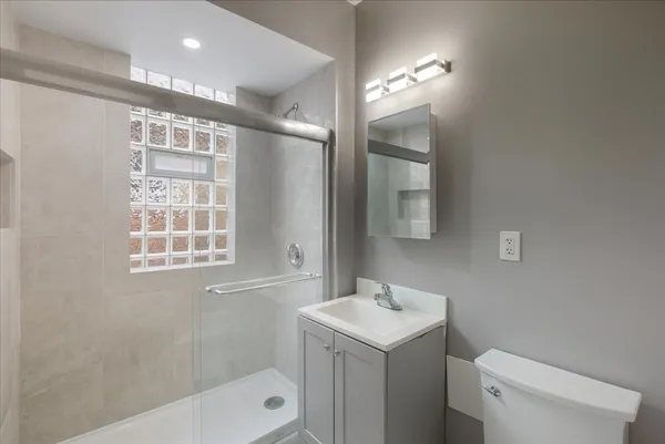 a bathroom with a sink a toilet and shower