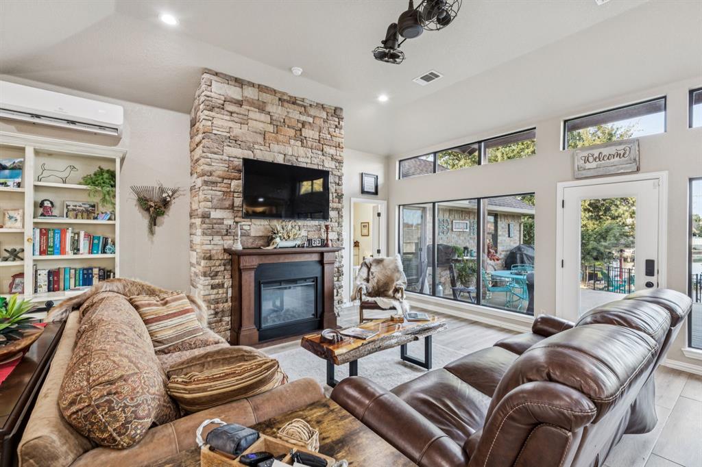 2325 River Road Granbury, TX 76048 - Photo 13 of 40 a living room with furniture a fireplace and a flat screen tv
