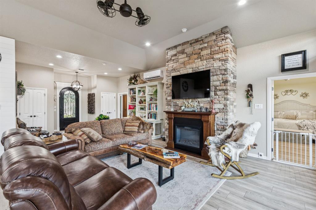 2325 River Road Granbury, TX 76048 - Photo 17 of 40 a living room with furniture a flat screen tv and a fireplace
