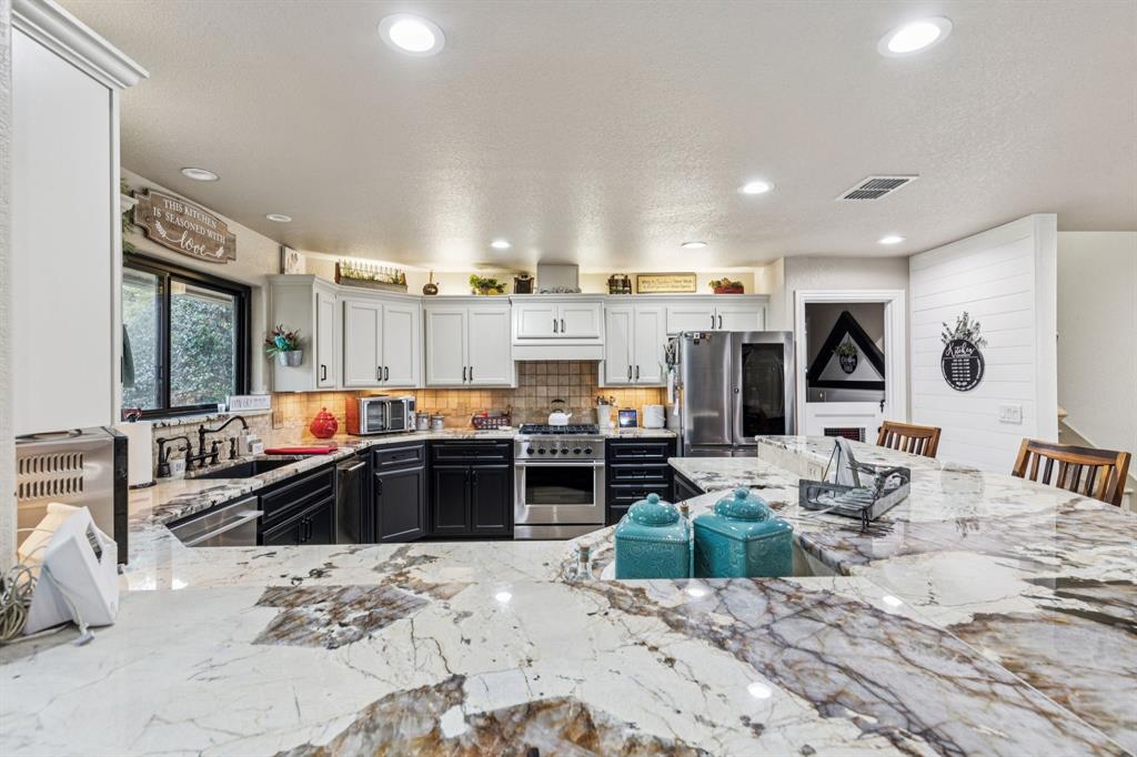 2325 River Road Granbury, TX 76048 - Photo 22 of 40 a kitchen with stainless steel appliances kitchen island granite countertop a refrigerator and stove