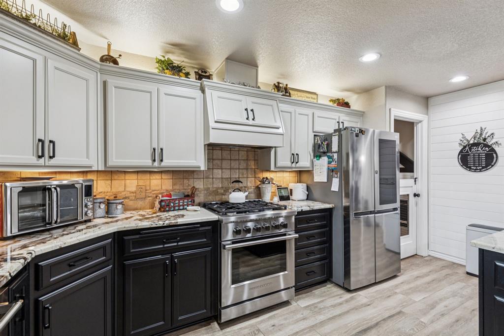 2325 River Road Granbury, TX 76048 - Photo 23 of 40 a kitchen with stainless steel appliances a refrigerator stove and sink