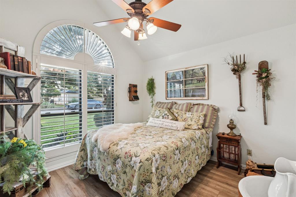 2325 River Road Granbury, TX 76048 - Photo 36 of 40 a bedroom with a large bed and a chandelier