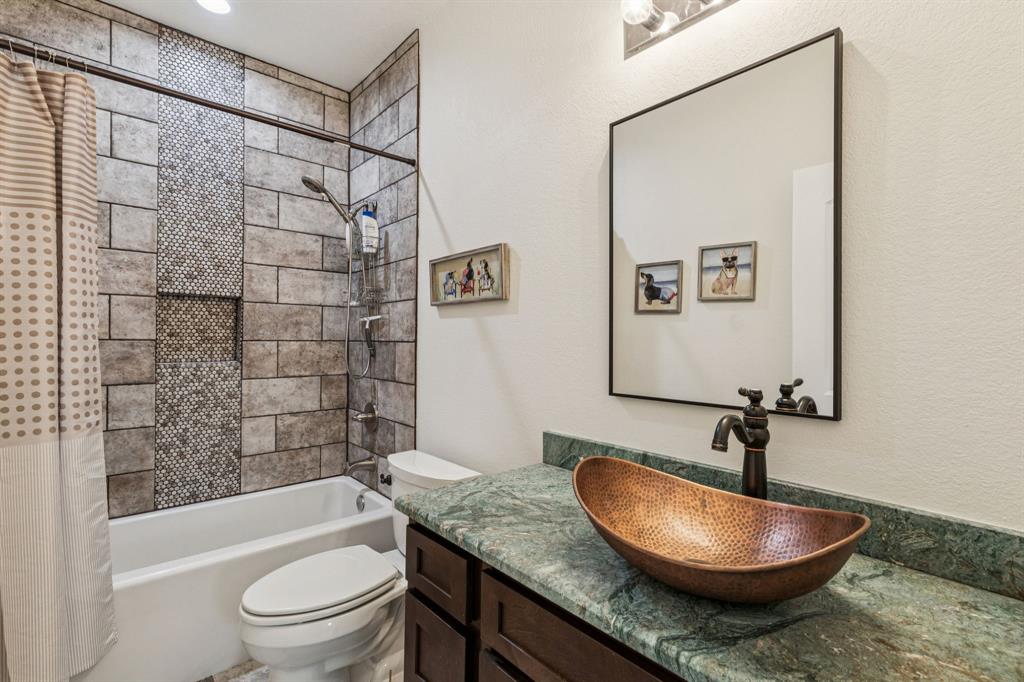 2325 River Road Granbury, TX 76048 - Photo 40 of 40 a bathroom with a granite countertop sink toilet a mirror and shower