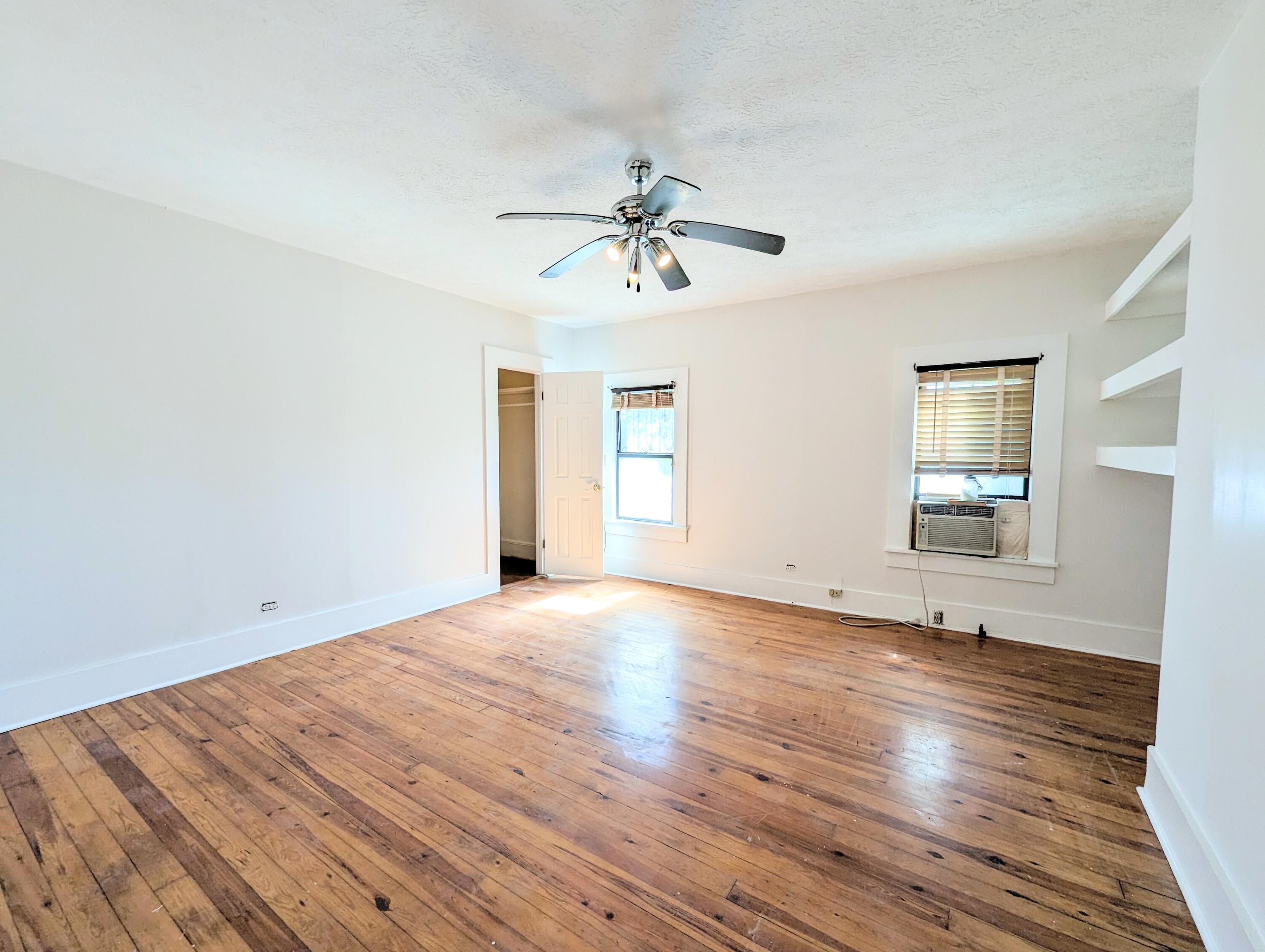 1335 Old Bonifay Road Chipley, FL 32428 - Photo 26 of 31 an empty room with wooden floor ceiling fan and windows