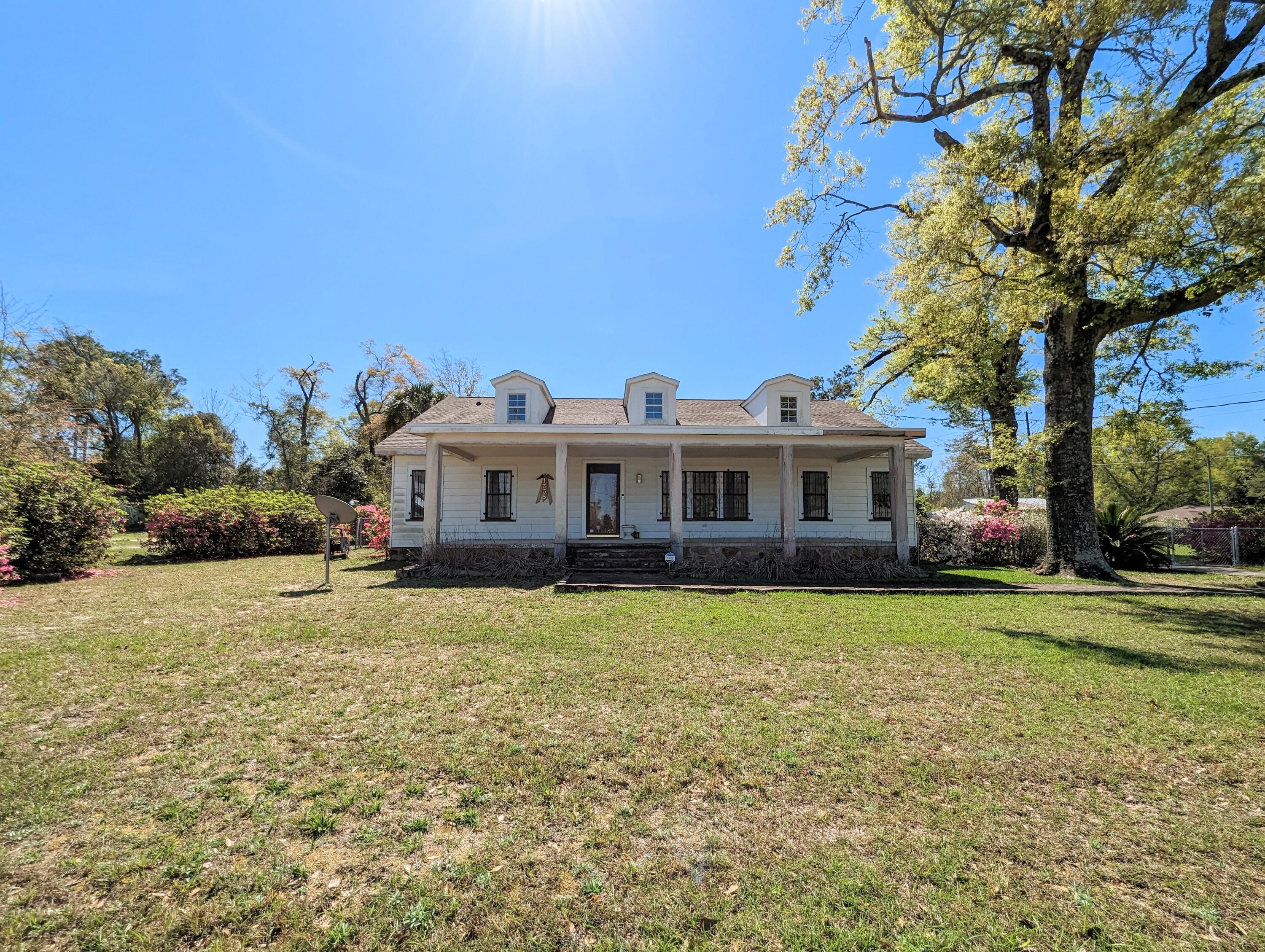 1335 Old Bonifay Road Chipley, FL 32428 - Photo 5 of 31 a front view of a house with a garden and trees