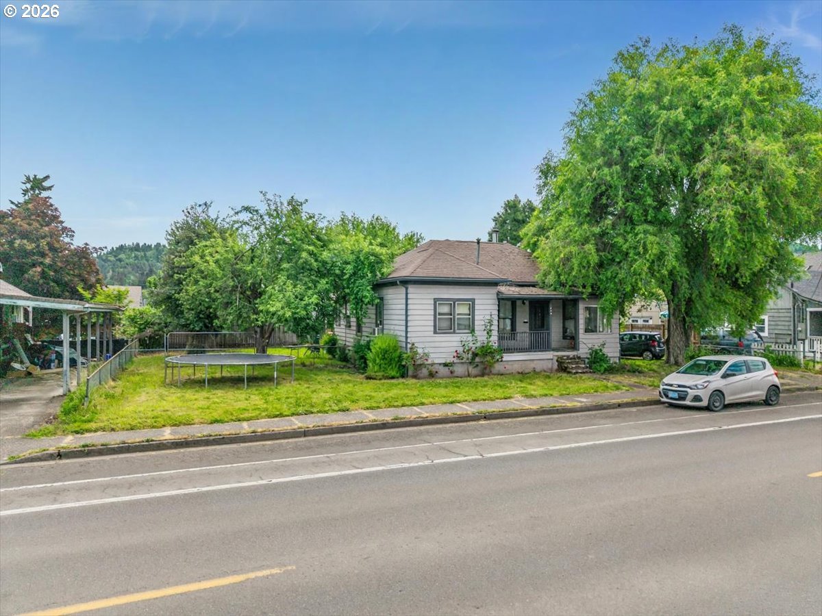 740 South 6th Street Cottage Grove, OR 97424 - Photo 3 of 21 a front view of a house with a garden and trees