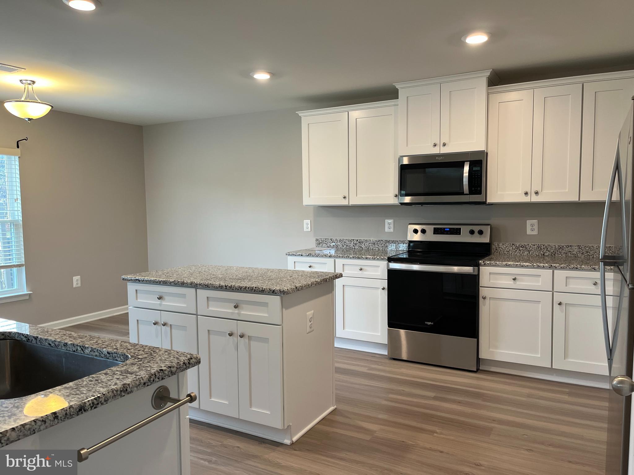 104 Rappahannock Run Falling Waters, WV 25419 - Photo 15 of 54 a kitchen with stainless steel appliances granite countertop a stove a sink and a microwave