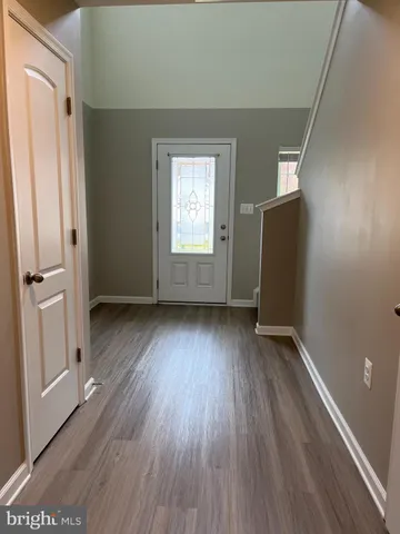 an empty room with wooden floor and a window