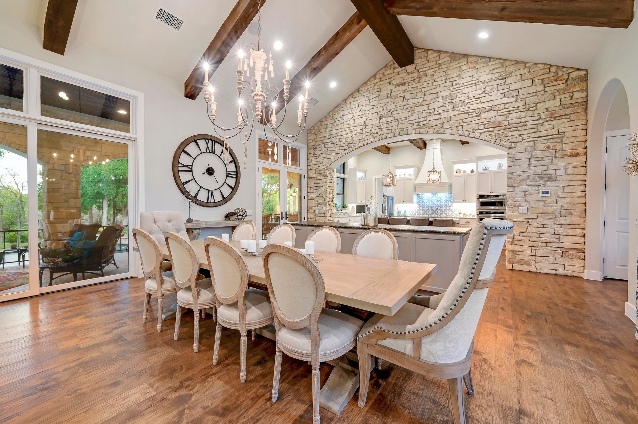 401 Trail Ridge Road Wimberley, TX 78676 - Photo 7 of 34 Dining space featuring beam ceiling, light wood finished floors, high vaulted ceiling, a chandelier, and arched walkways