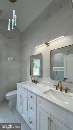 a bathroom with a double vanity sink toilet and a mirror
