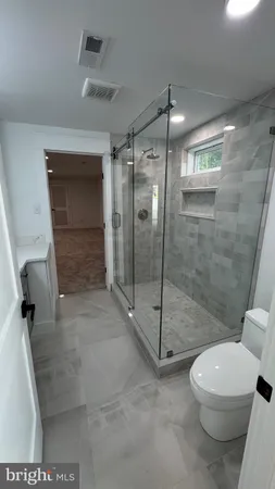 a bathroom with a shower a toilet and a sink