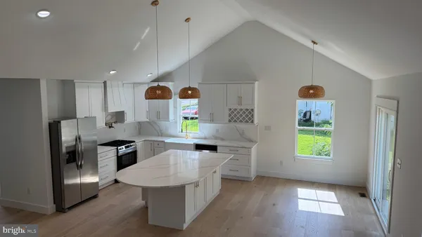 a view of kitchen with windows and refrigerator