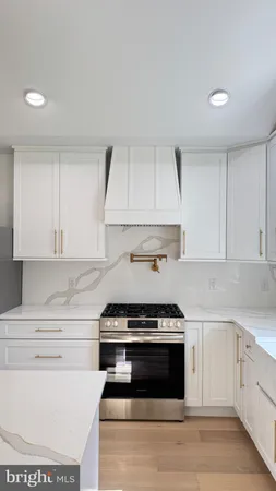 a kitchen with granite countertop white cabinets and stainless steel appliances