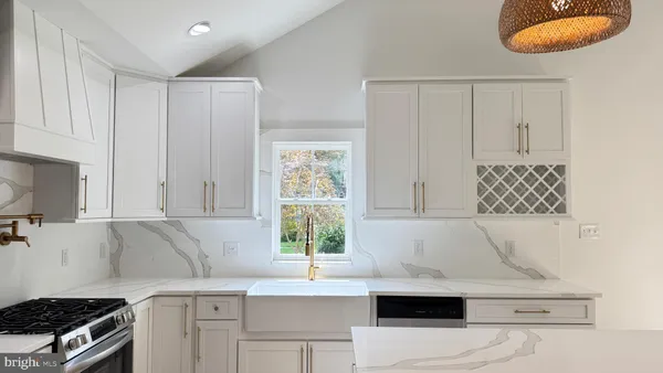 a kitchen with granite countertop white cabinets and a stove