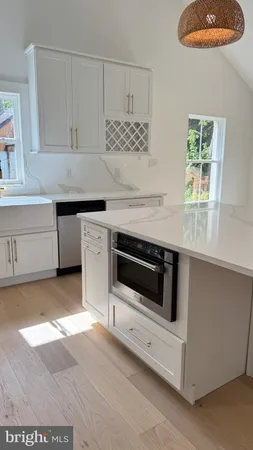 a kitchen with granite countertop white cabinets and white appliances