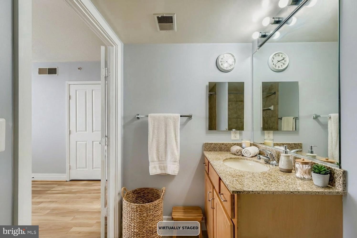 414 Water Street, Unit 1703 Baltimore, MD 21202 - Photo 15 of 34 a bathroom with a granite countertop sink and a mirror
