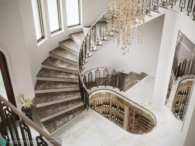 a view of staircase with lots of frames on wall and a window