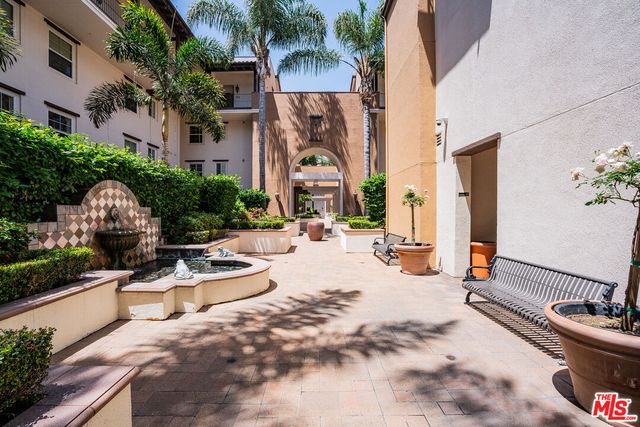 a row of palm trees in front of a building