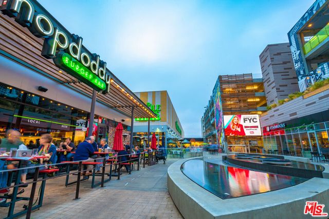 a group of people standing around a fruit stand