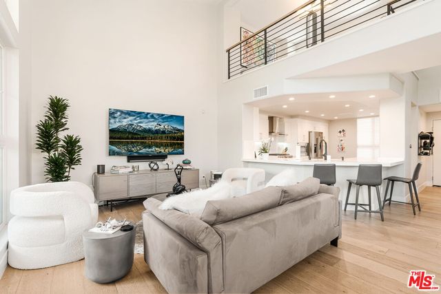 a dining hall with stainless steel appliances a dining table chairs and couches