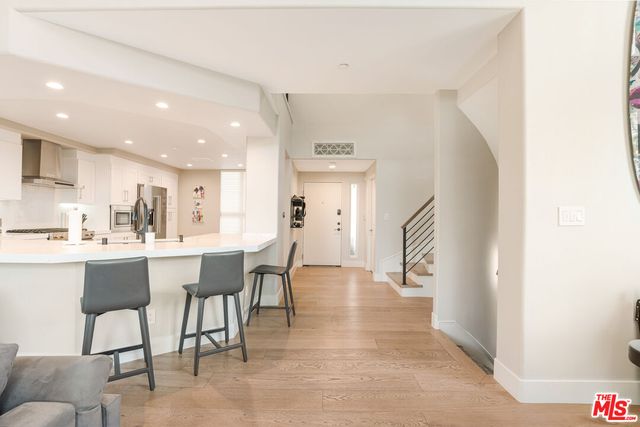 a kitchen with a dining table chairs and wooden floor