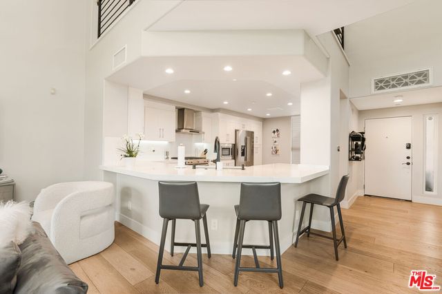 a kitchen with white cabinets and white stainless steel appliances