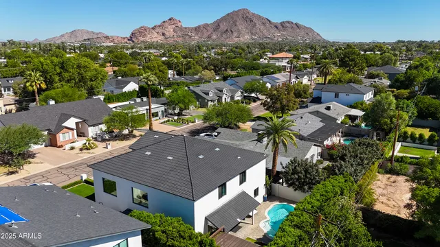 an aerial view of a house with a mountain