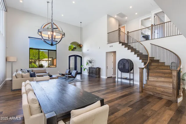 a view of a dining room and livingroom with furniture wooden floor a chandelier