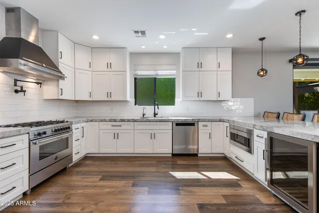 a kitchen with stainless steel appliances granite countertop a stove sink and cabinets