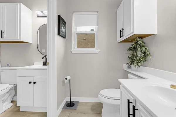 a bathroom with a sink a toilet and mirror