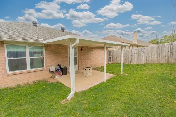 a view of a backyard with table and chairs and wooden fence