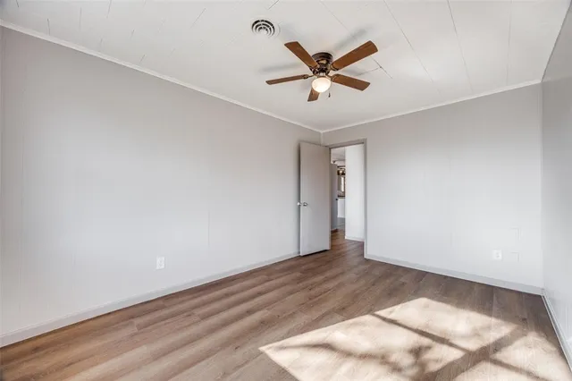 a view of a big room with wooden floor and windows