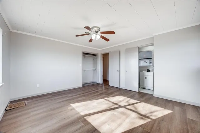 a view of a room with wooden floor and a ceiling fan