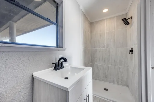 a bathroom with a shower a sink and mirror