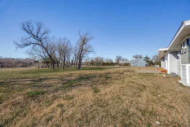 a view of dirt field with trees