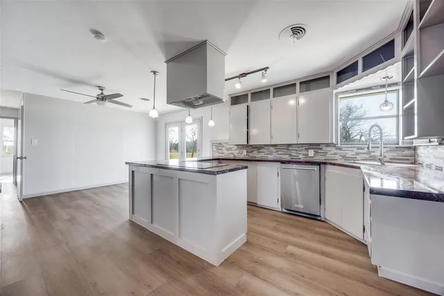 a kitchen with stainless steel appliances granite countertop a white cabinets and wooden floor