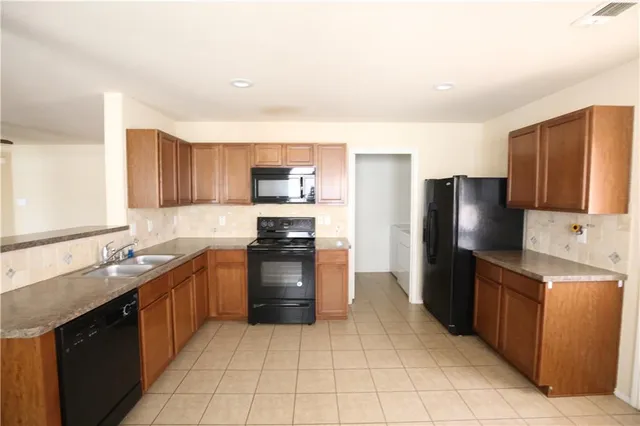 a kitchen with stainless steel appliances granite countertop a refrigerator stove and sink