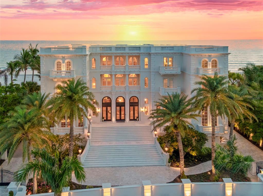 a front view of multiple houses with palm trees