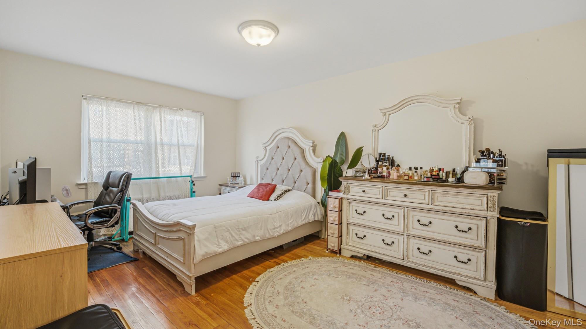 141-01 Jewel Avenue Queens, NY 11367 - Photo 19 of 21 a bedroom with a bed and a dresser