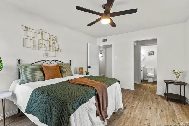 a spacious bedroom with a bed and wooden floor