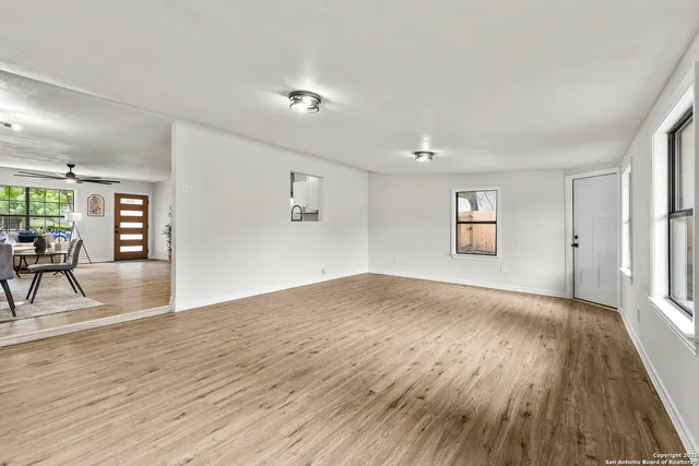 a view of empty room with wooden floor and fireplace