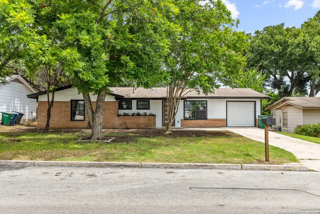 a front view of a house with a yard and a garage