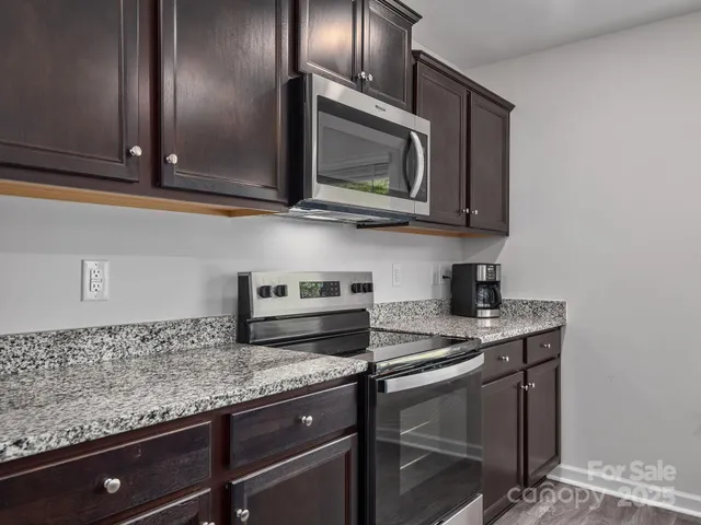 a kitchen with granite countertop cabinets stainless steel appliances and a sink