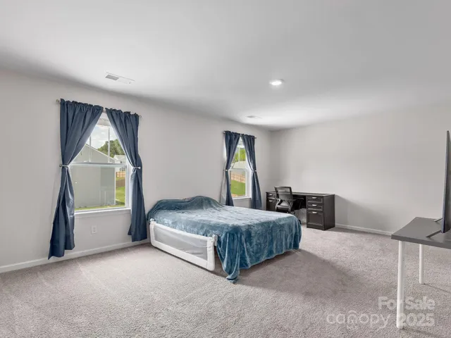 a spacious bedroom with a bed and window