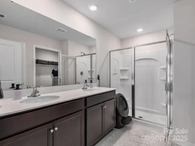 a bathroom with a double vanity sink a mirror and a shower