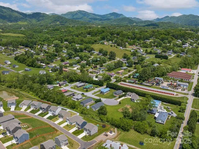 an aerial view of a city with lots of residential buildings and mountain view in back